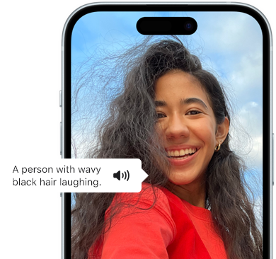 Az iPhone 15 egy Voiceover-bejelentést jelenít meg, amely a következőképp ír le egy fotót: egy hullámos fekete hajú ember nevet