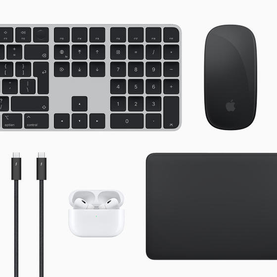 Mac-kiegészítők felülnézetből: Magic Keyboard, Magic Mouse, Magic Trackpad, AirPods és Thunderbolt-kábelek