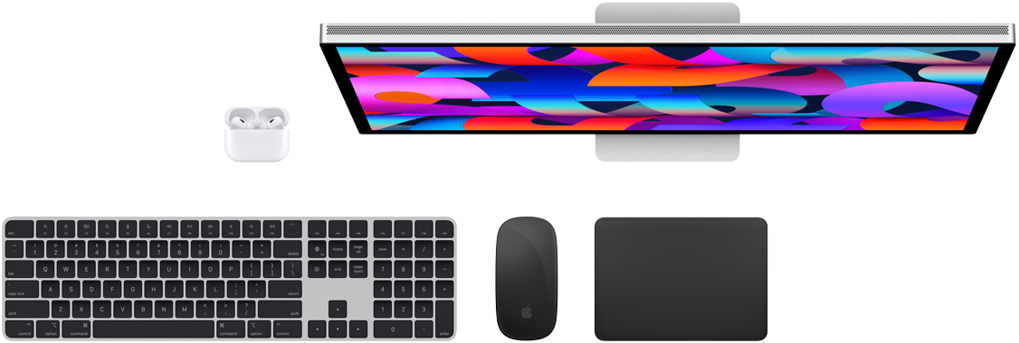 Mac-kiegészítők felülnézetből: Studio Display, AirPods, Magic Keyboard, Magic Mouse és Magic Trackpad