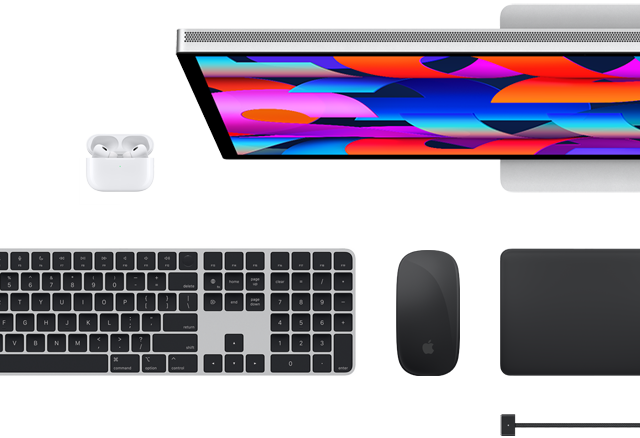 Mac-kiegészítők felülnézetből: Studio Display, Magic Keyboard, Magic Mouse, Magic Trackpad, AirPods és MagSafe töltőkábel
